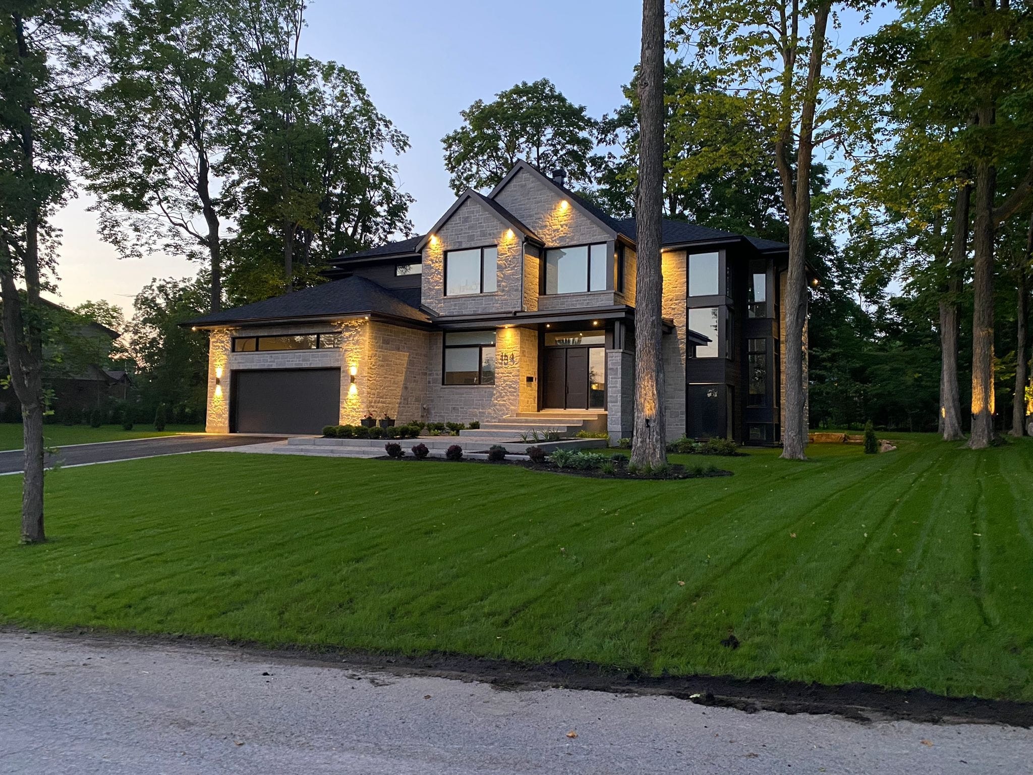 Cour de maison avec surface gazonnée et aménagement paysager simple dans un quartier résidentiel  à Sainte-Anne-des-Lacs